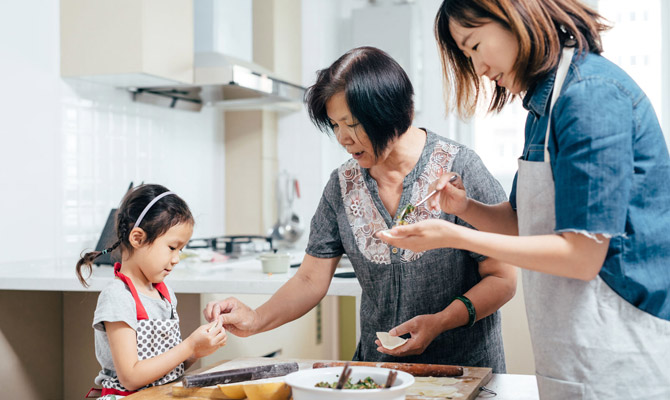 Little girl and her mother cooking with grandma