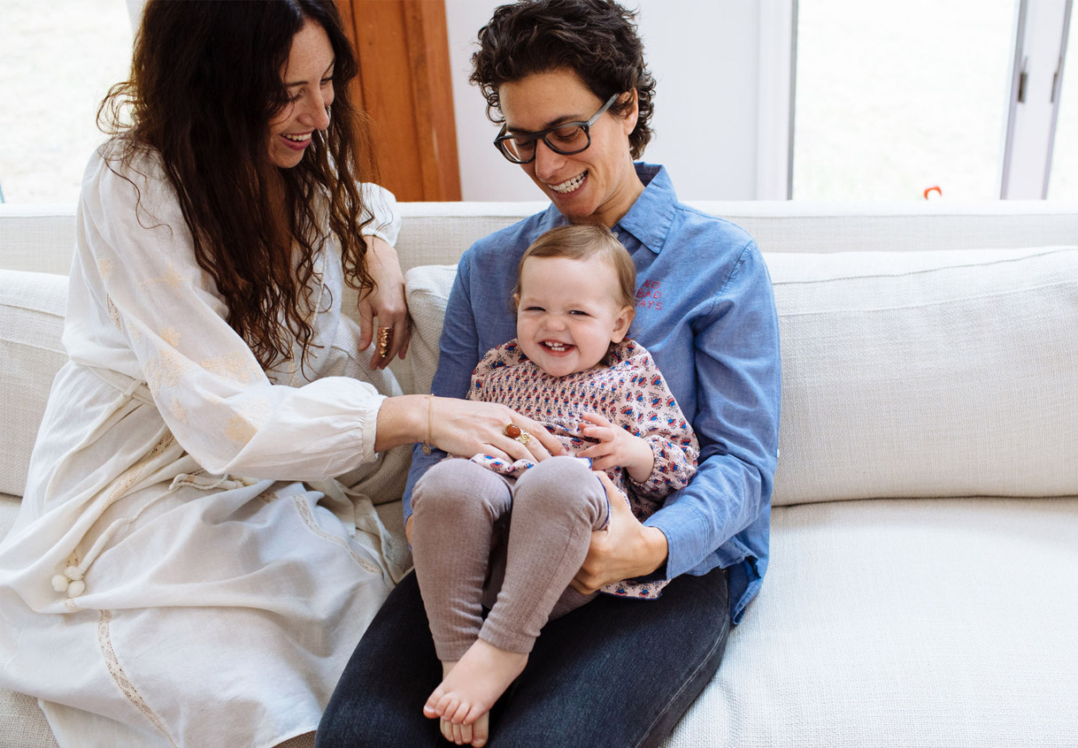 Two women with laughing child