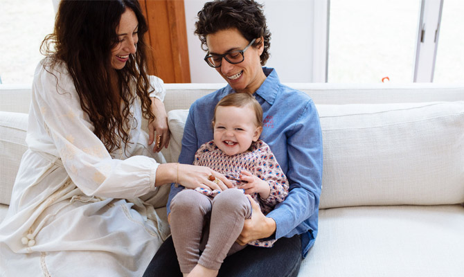 Two women with laughing child